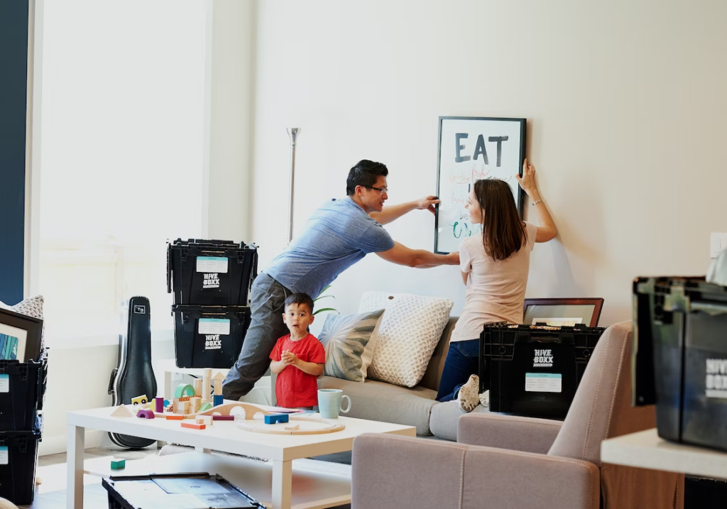 Family hanging up their new artwork inside their home